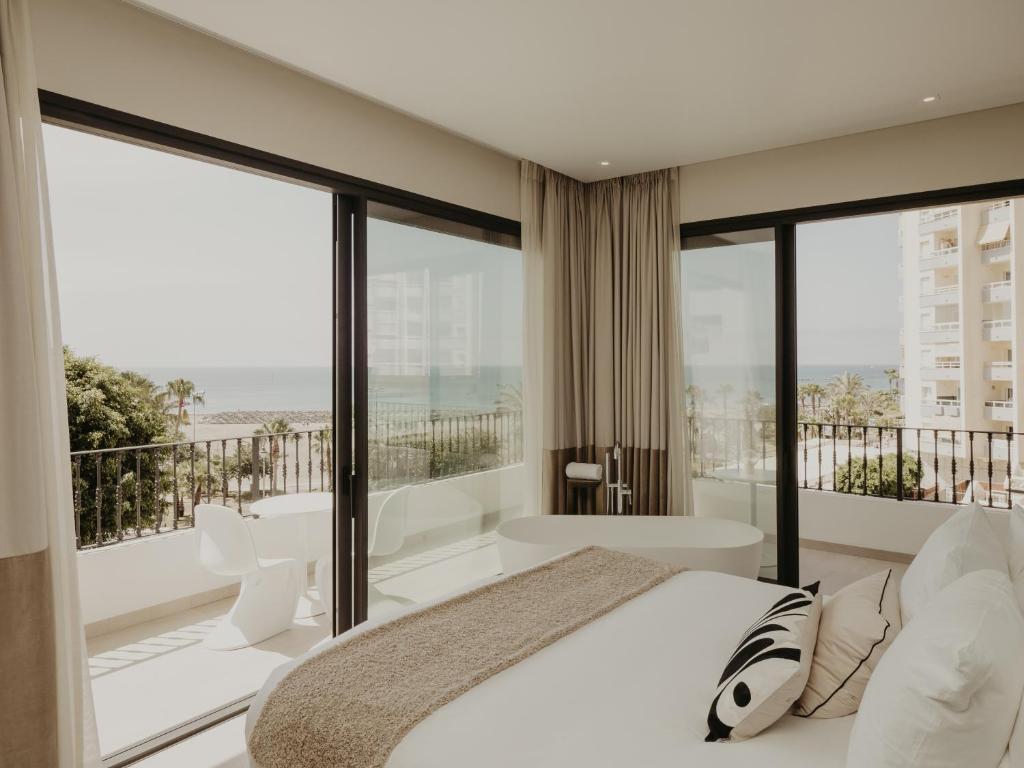 a bedroom with a bed and large glass windows at Comfy Studios in Benalmádena