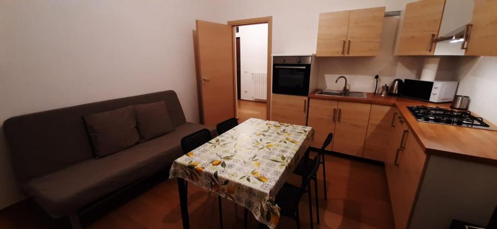 a small kitchen with a table and a couch at CASA VACANZA IL BALCONCINO in Bergamo