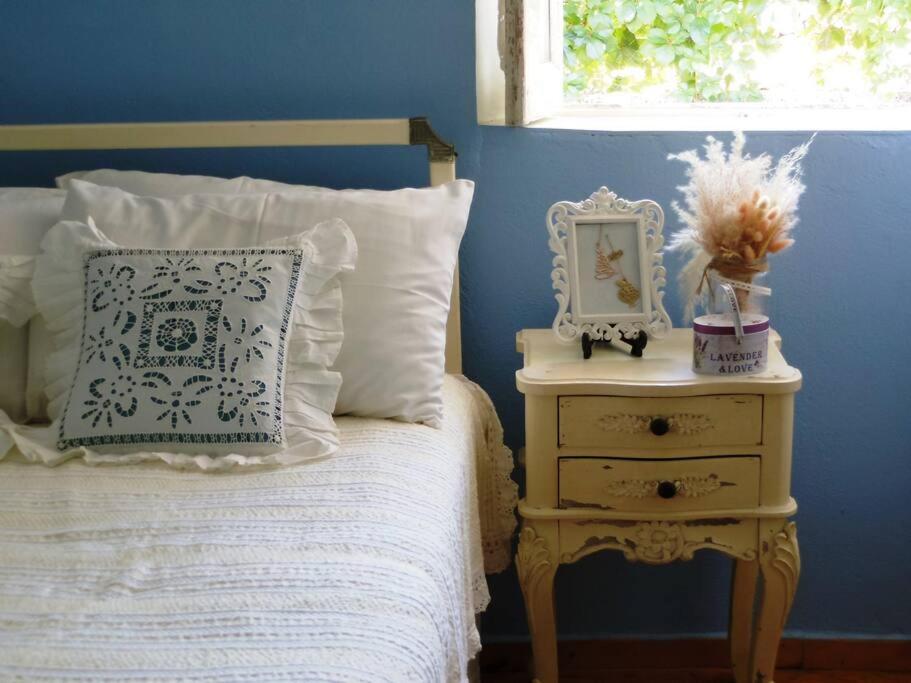 a blue bedroom with a bed and a nightstand with a clock at 1882 Vintage in Drymon
