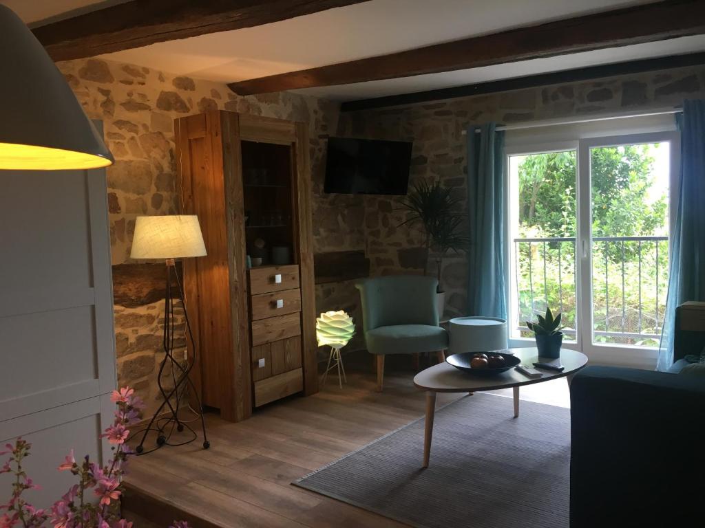 a living room with a table and a window at Gites Còr Causy OLEANDER in Causses-et-Veyran