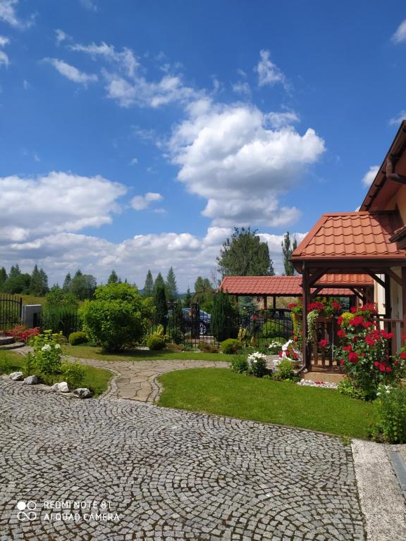 un jardín con cenador y un camino de piedra en Apartament Radochów 138G, en Lądek-Zdrój