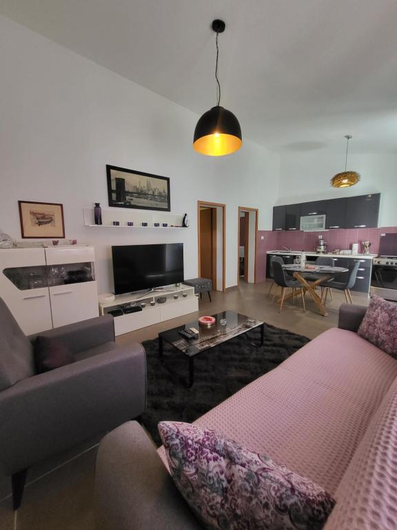 ein Wohnzimmer mit einem Sofa und einem TV in der Unterkunft Happy house in Split