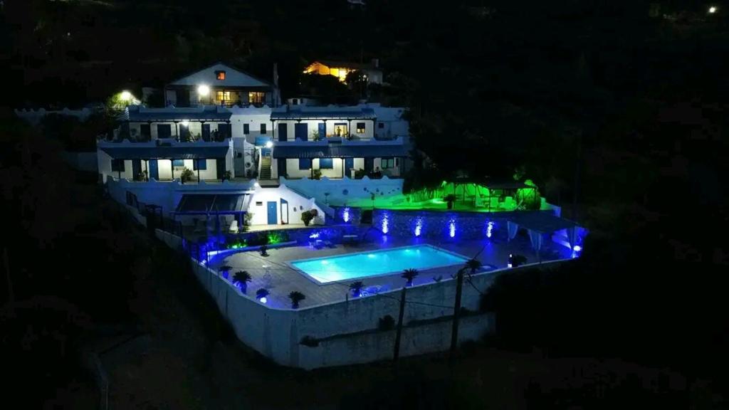 una casa grande con piscina por la noche en Studios Avra, en Akhladherí