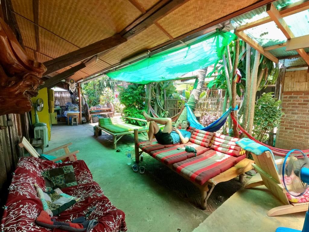 une chambre avec des canapés et un hamac dans une maison dans l'établissement Sunny garden hostel, à Pai