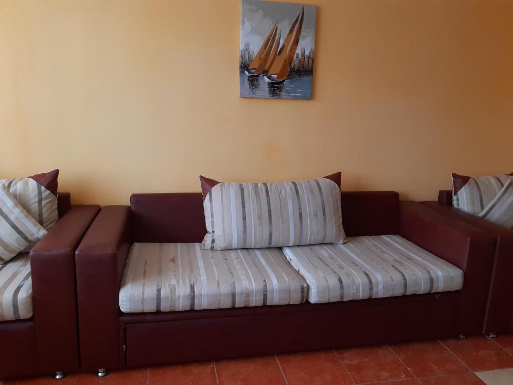 eine braune Couch mit gestreiftem Kissen drauf in der Unterkunft Apartament Gabriela in Mangalia