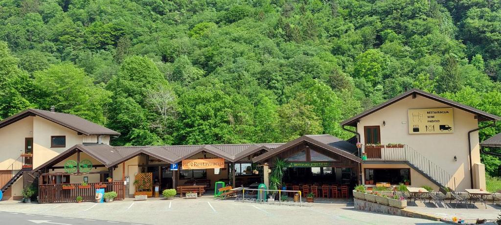 um edifício num parque de estacionamento em frente a uma montanha em Rooms Tolminska korita em Tolmin