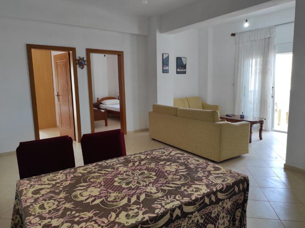 um quarto com uma cama e uma sala de estar com um sofá em Sweet Apartment em Saranda