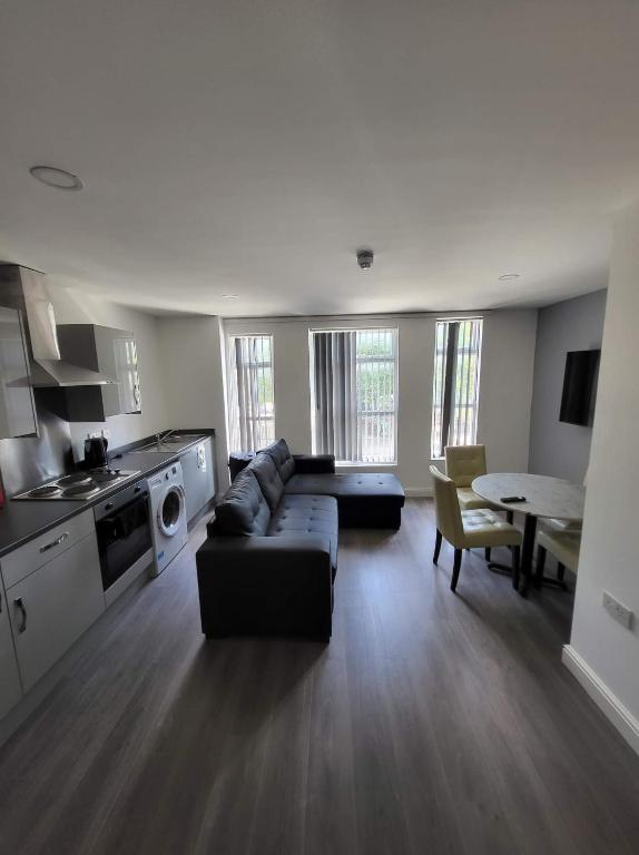 a large living room with a couch and a kitchen at Avenue Apartments in Hull