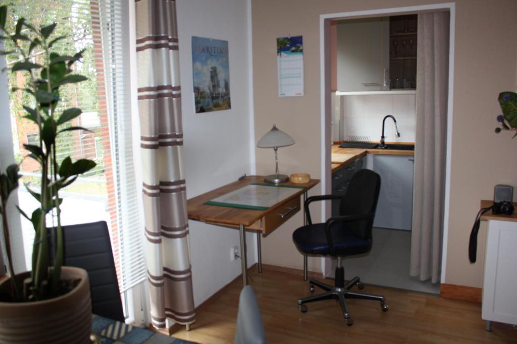 Cette chambre dispose d'un bureau, d'une chaise et d'une cuisine. dans l'établissement Zentral gelegene Ferienwohnung, à Lübeck