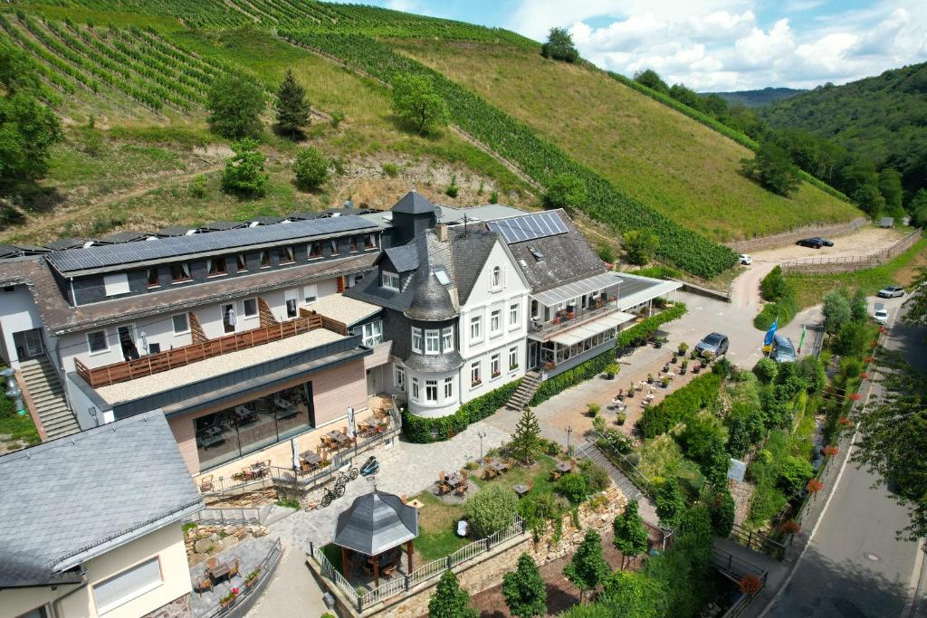 eine Luftansicht eines Herrenhauses mit einem Hügel im Hintergrund in der Unterkunft Hotel Weinberg-Schlößchen in Oberheimbach