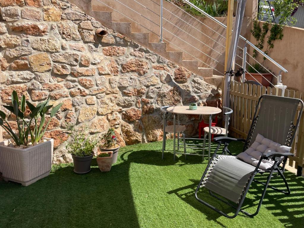 イエールにあるAppartement en rez-de-villa avec jardinの小さな庭園(芝生の上にテーブルと椅子付)
