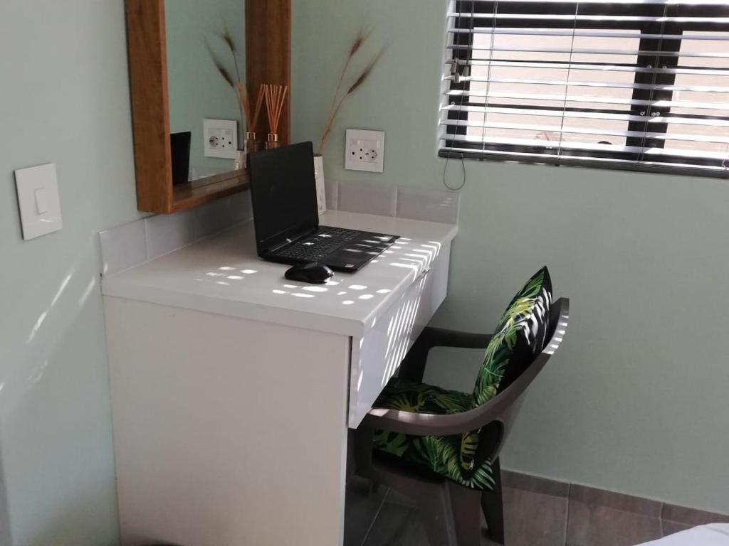 a laptop computer sitting on top of a white desk at Calla—Cottage in Ballito