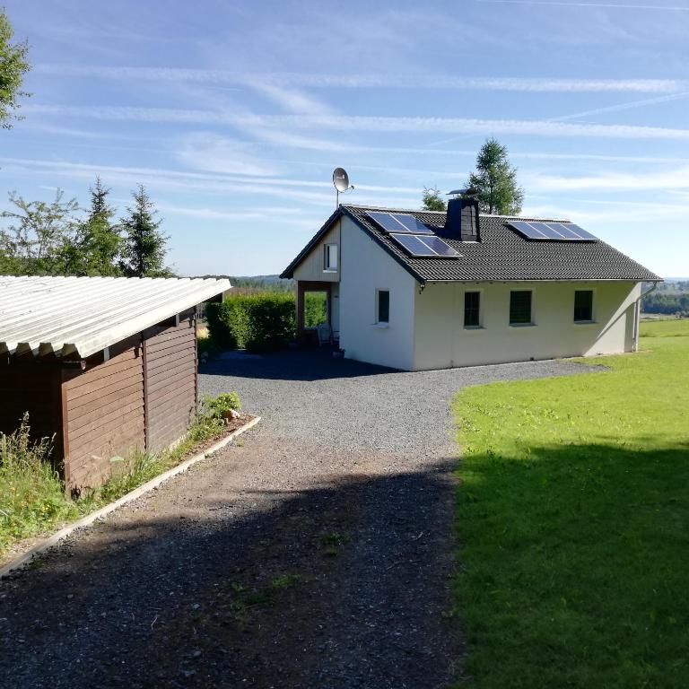 a white house with solar panels on the roof at Ferienhaus mit Ausblick in Brilon