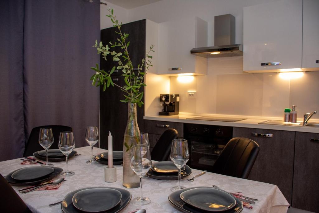 einen Tisch mit Tellern und Gläsern und eine Vase mit Blumen in der Unterkunft Apartment 7 in Novi Vinodolski