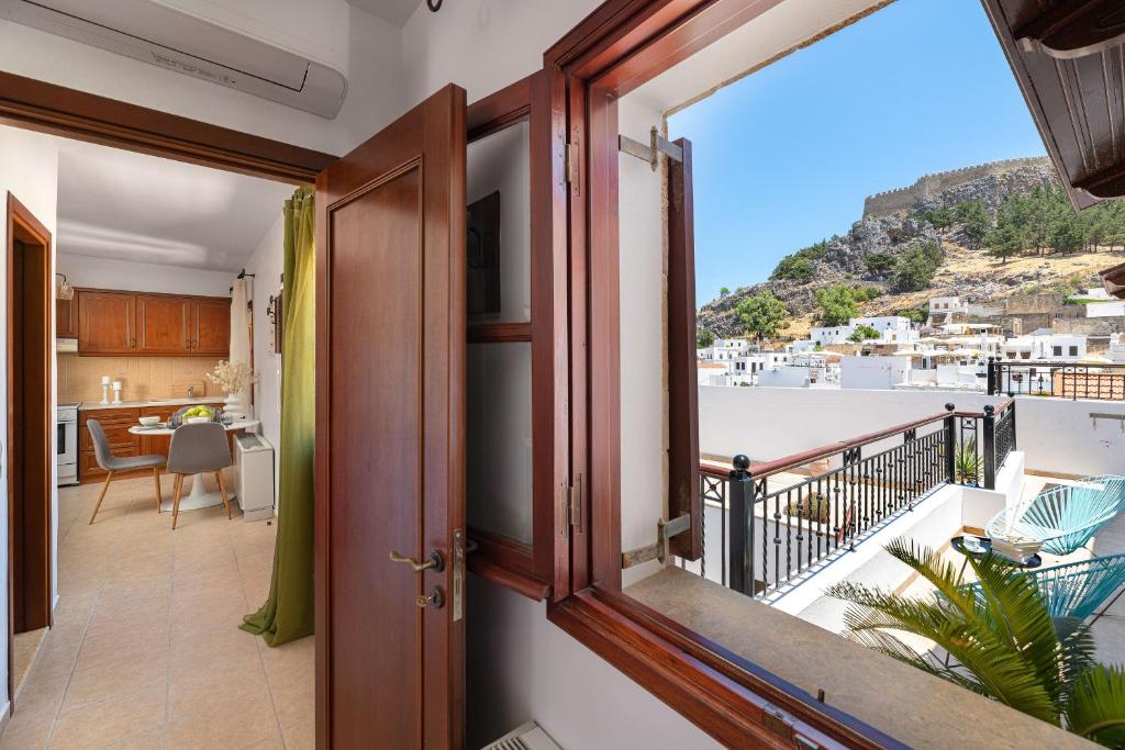 a room with a balcony with a view of the ocean at Lindos Luxury Belfry Apartment in Lindos