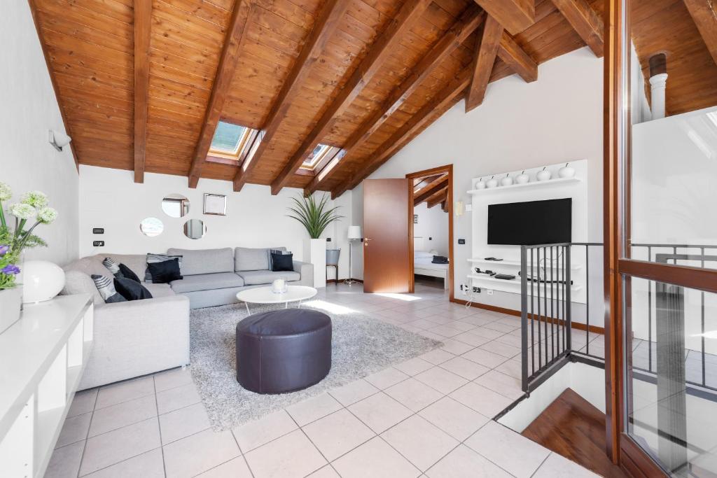 ein Wohnzimmer mit einem Sofa und einem TV in der Unterkunft CasaCamelia 35, 3 BDRM with view Lake Como in Acquaseria