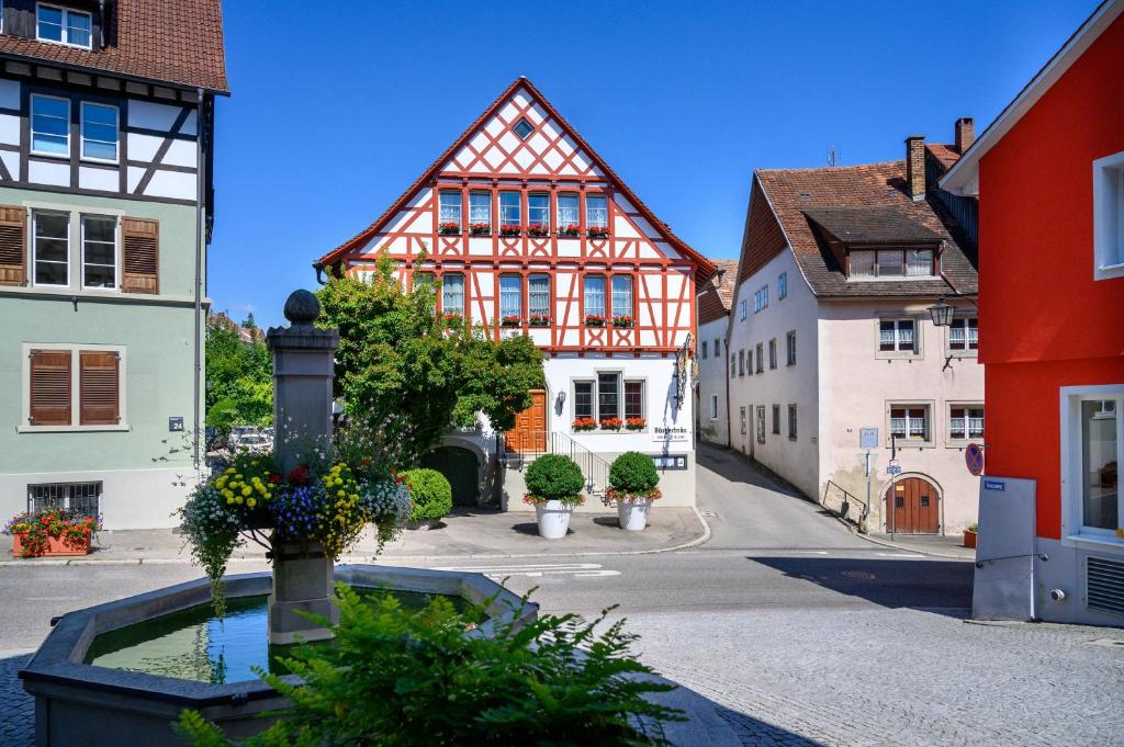 a city street with buildings and a fountain with flowers at Bürgerbräu in Überlingen