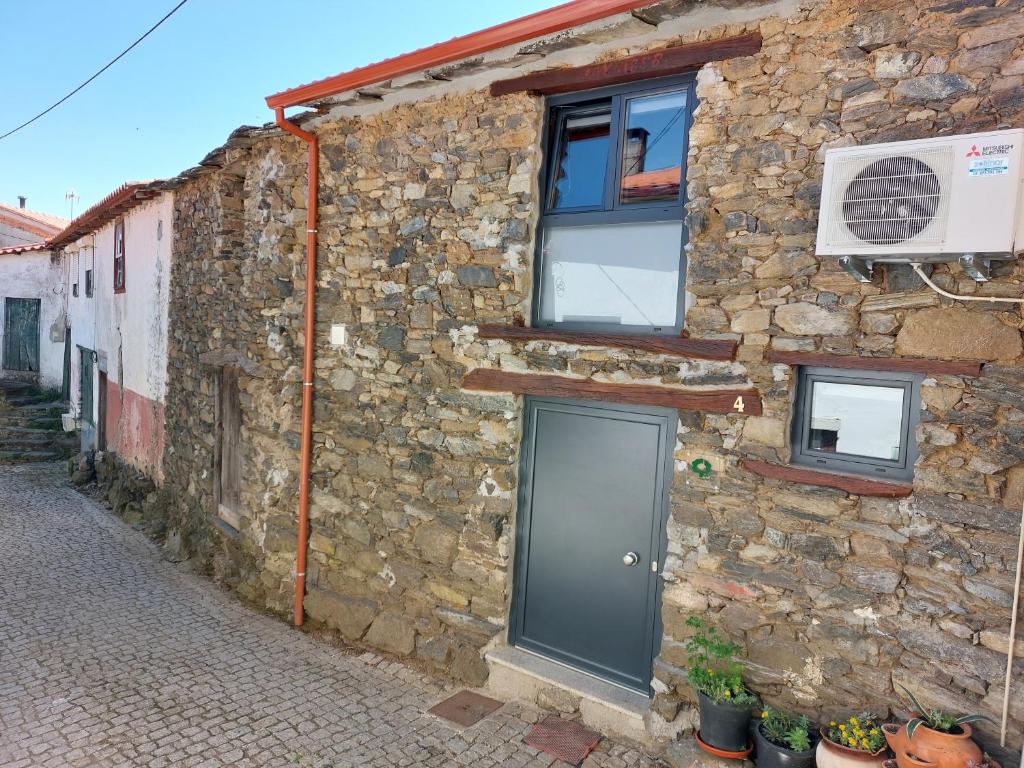 kamienny budynek z drzwiami i oknami w obiekcie O Palheirinho - Turismo Rural - Bragança w mieście Samil