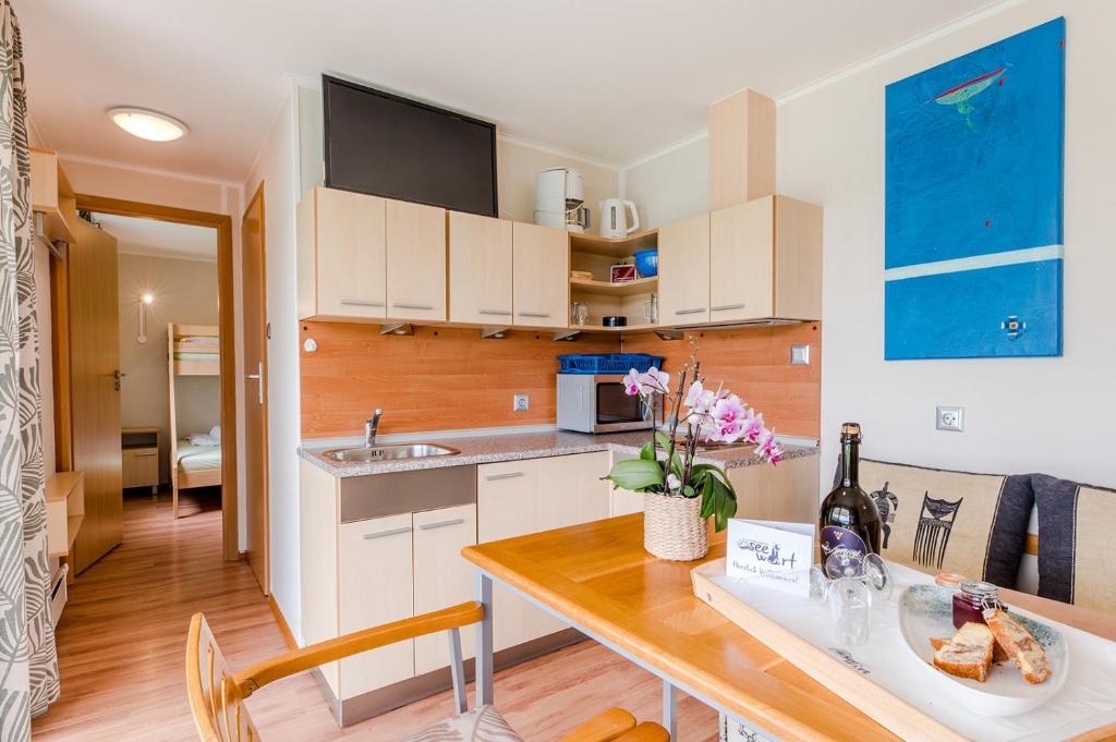 eine Küche mit weißen Schränken und einem Holztisch in der Unterkunft Relax Camping Seewirt in Feldkirchen in Kärnten
