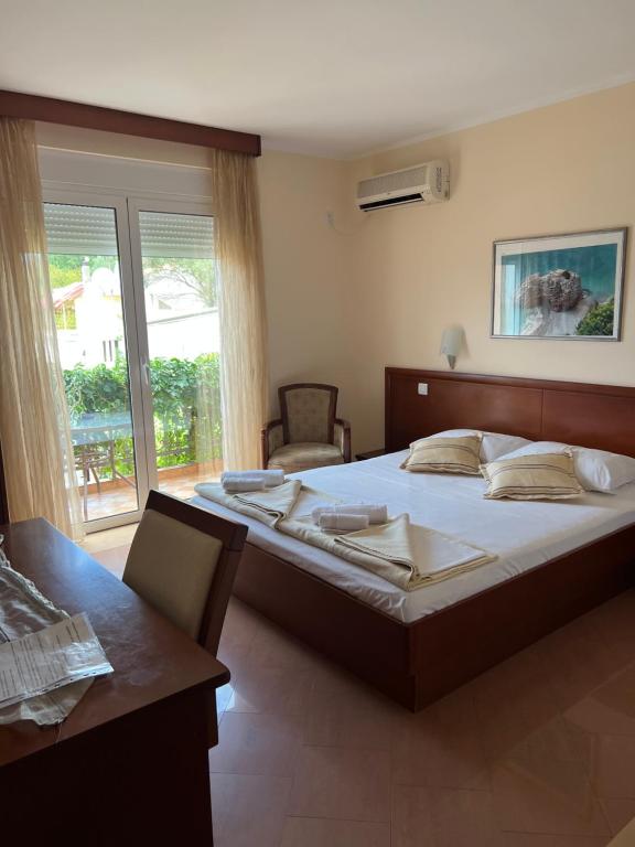 a bedroom with a large bed and a table at Apartments Villa Sveti Nikola in Budva