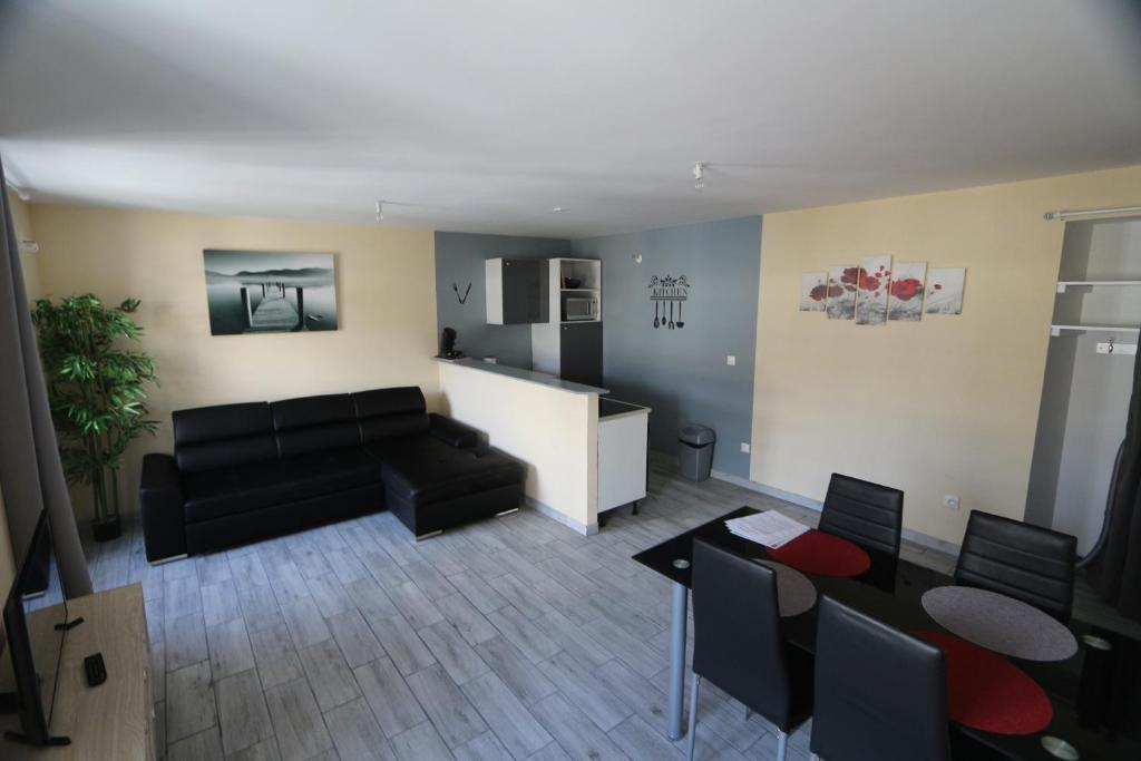 a living room with a black couch and a table at Appart Hotel cholet centre in Cholet