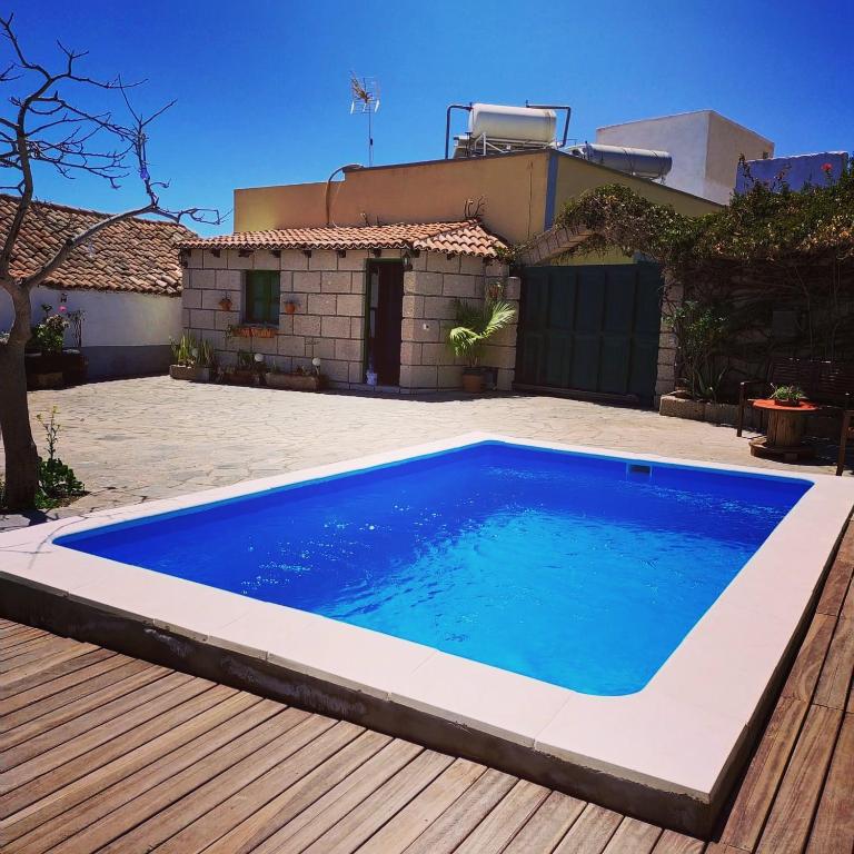 a blue swimming pool in front of a house at Villa los gavilanes in Santa Cruz de Tenerife