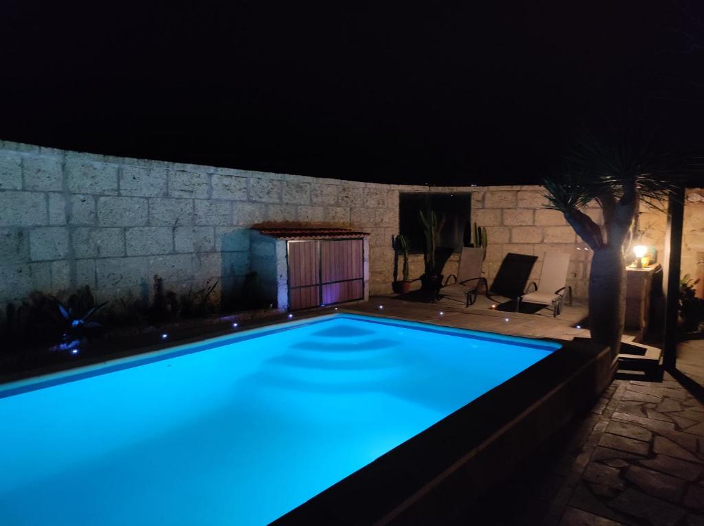 uma piscina à noite com luzes azuis em Villa los gavilanes em Santa Cruz de Tenerife