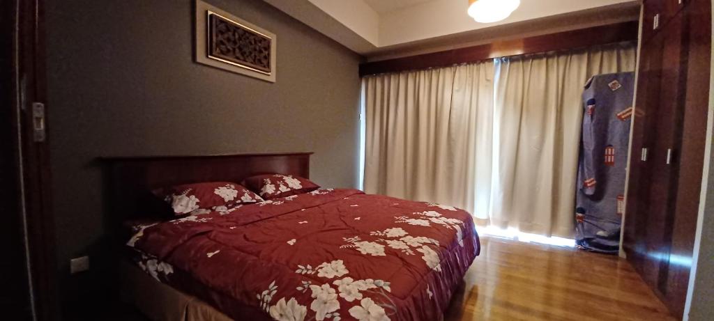 スクダイにあるClassical Romantic Pulai Springsのベッドルーム1室(赤い掛け布団、窓付)