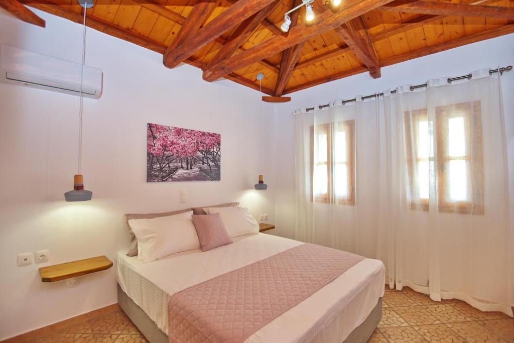 ein Schlafzimmer mit einem Bett und zwei Fenstern in der Unterkunft PETRINO in Alonnisos Altstadt