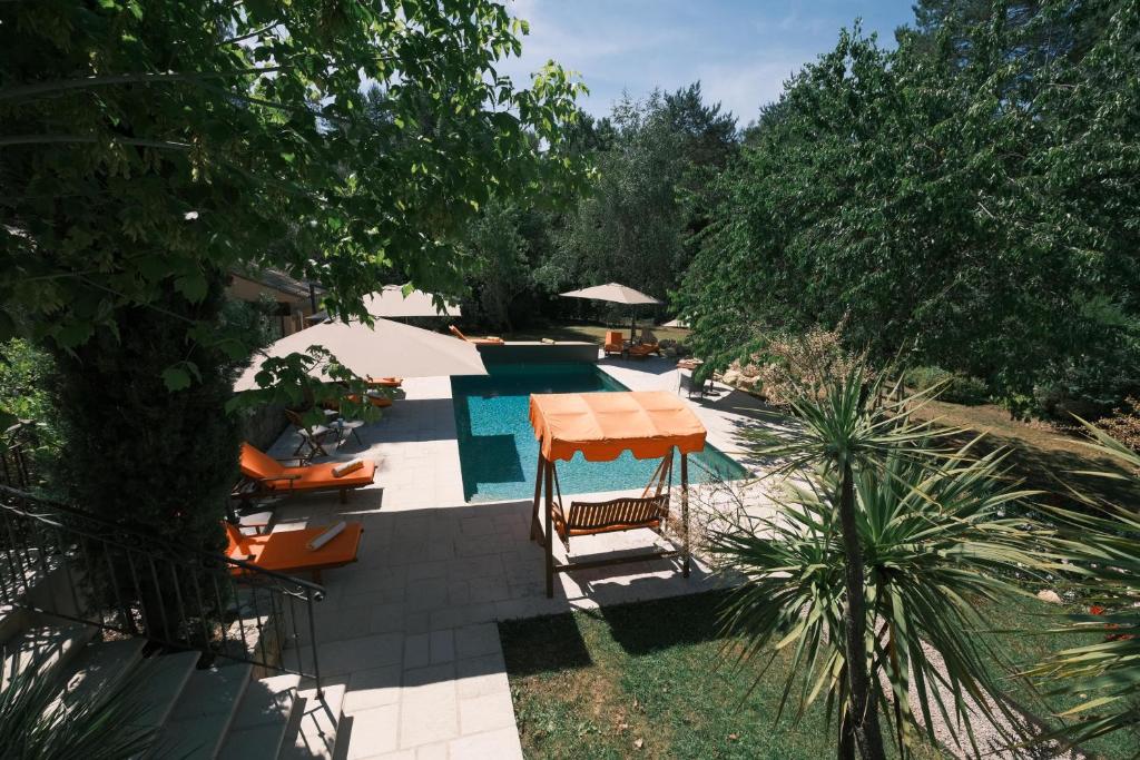 una piscina con mesa, sillas y árboles en Ekin ô reV Gîte Fontessante, en Montauroux
