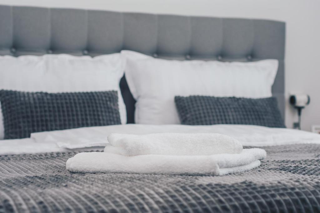 una pila de toallas sentadas encima de una cama en L Apartment en Maribor