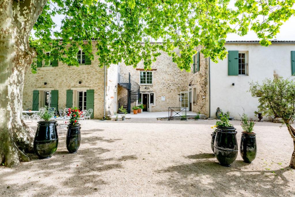 een groep zwarte containers gevuld met bloemen voor een gebouw bij Hôtel & SPA Ventoux Provence "Domaine des Tilleuls" in Malaucène