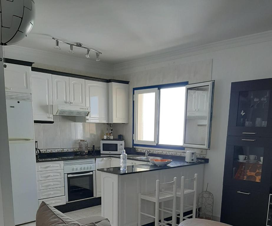 a kitchen with white cabinets and a counter top at Apartamento vacacional en Orzola Lanzarote in Orzola