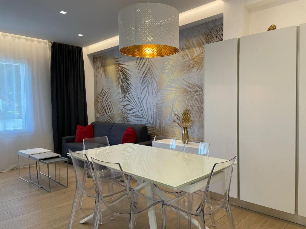 una sala da pranzo con tavolo e sedie bianchi di Arcioun Suite a Riccione