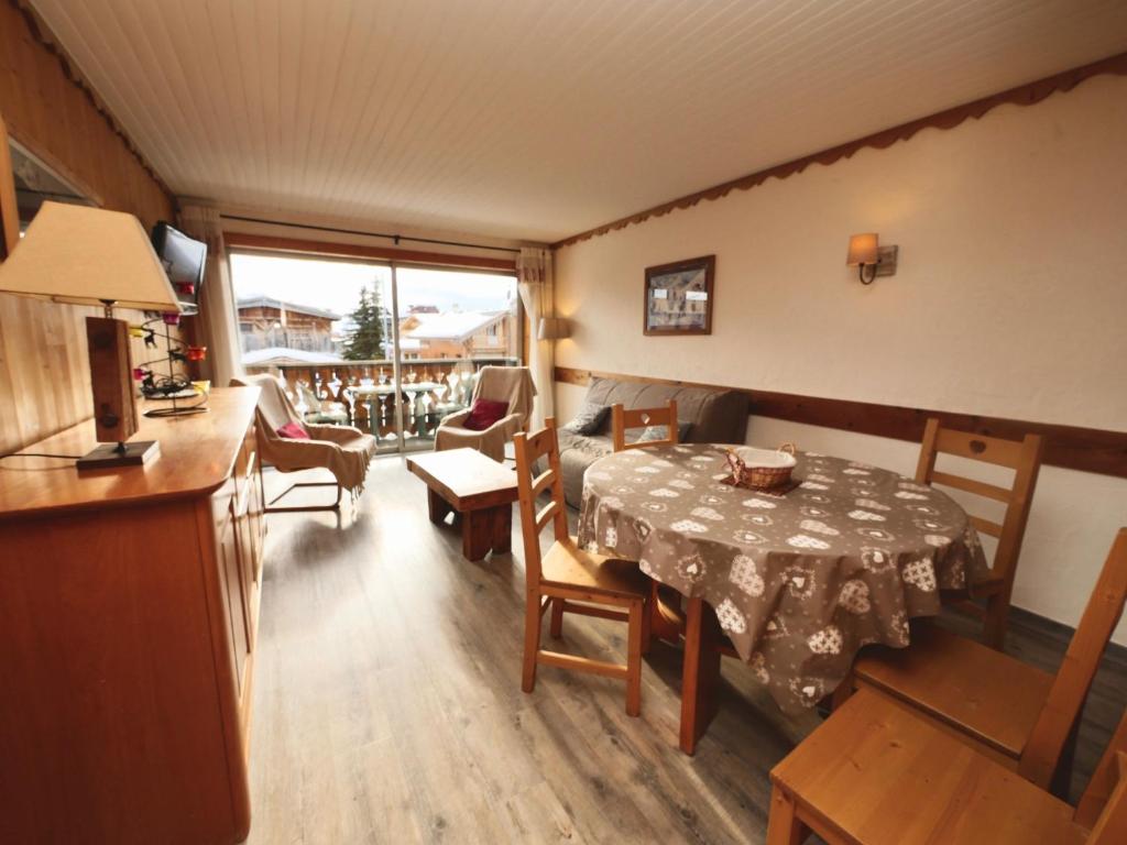 d'un salon avec une table et d'une chambre avec un balcon. dans l'établissement Crocus N3, à Huez