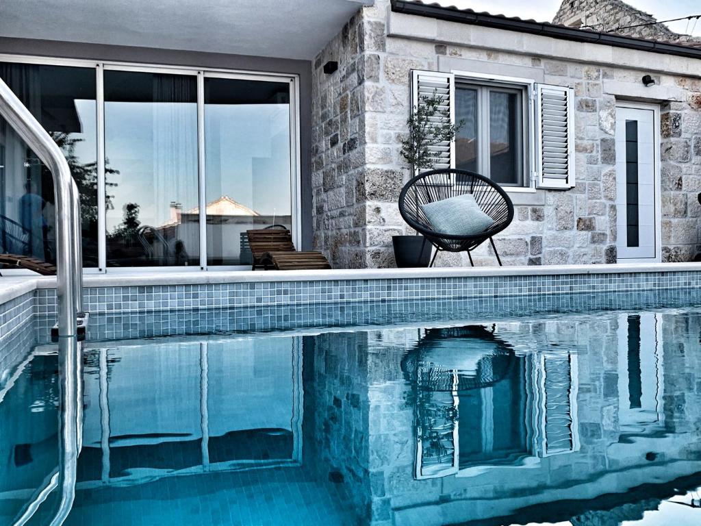 a swimming pool with a chair next to a house at Villa Azzuro in Selca