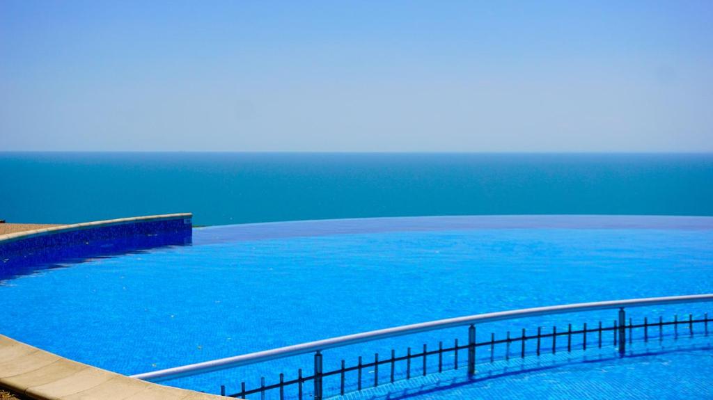 カヴァルナにあるМорски Апартаменти Джулай Морнинг - July Morning Sea View Apartmentsの青い水の大きなプール(フェンス付)