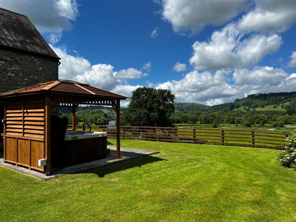 a wooden gazebo in the middle of a field at Cwmgwn Farm in Llandovery