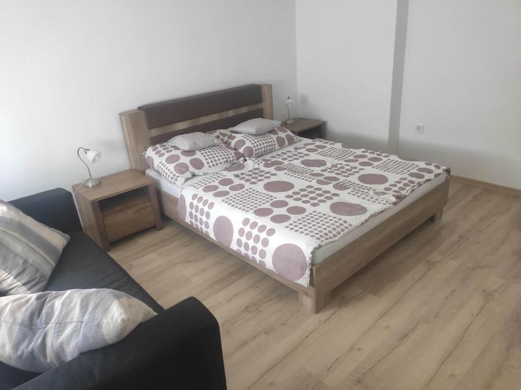 a bedroom with a bed and a couch at Balatonalmádi Kazinczy apartman in Balatonalmádi