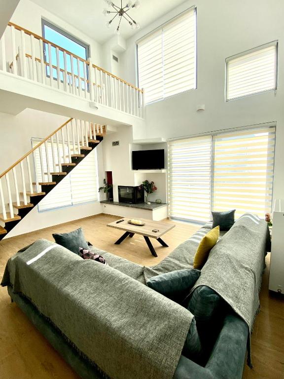 a living room with a couch and a staircase at Loft House Zante in Argassi