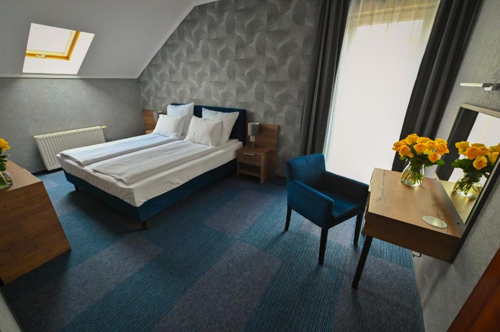 a bedroom with a bed and a table and a chair at Hotel Rad in Grudziądz