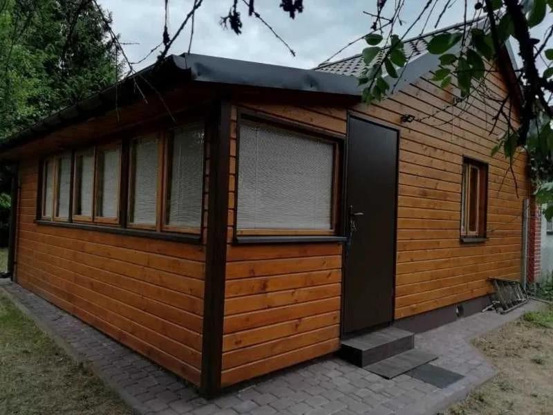 een hut met een zwarte deur en ramen bij Wypoczynek Gawrych Ruda in Gawrych Ruda
