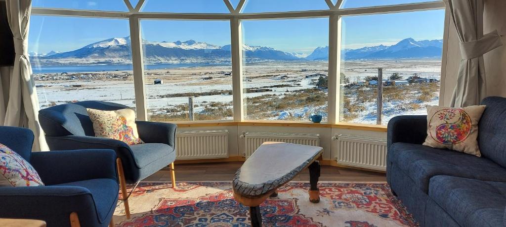 ein Wohnzimmer mit 2 Stühlen und einem großen Fenster in der Unterkunft Dome with Stunning Glacier & Mountain Views in Puerto Natales