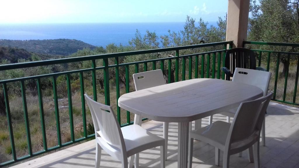 un tavolo bianco e sedie su un balcone con vista sull'oceano di Oasi Petrus Cilento B&B a Marina di Camerota
