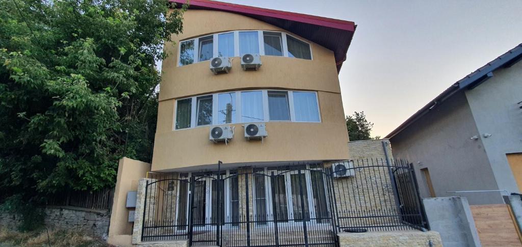a building with three windows and a fence at Casa Tim in Tulcea