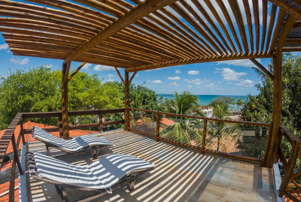 a deck with two chairs and a view of the ocean at Swiss Garten Jeri in Jericoacoara