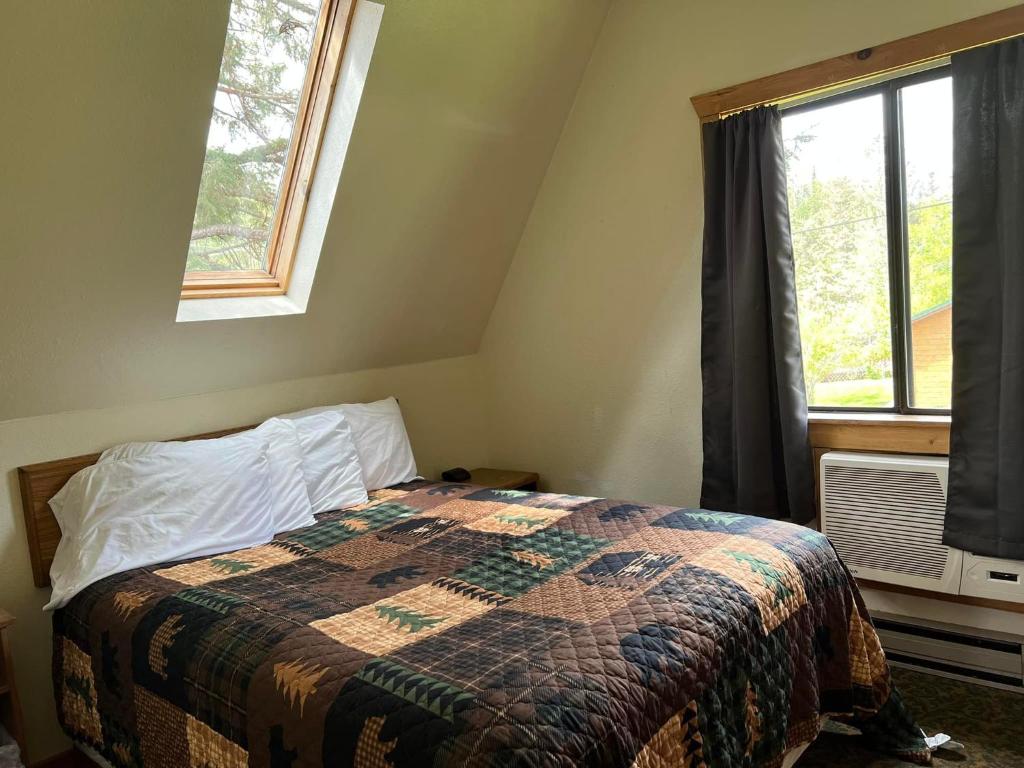 a bedroom with a bed with a quilt and a window at Chalet in Hill City