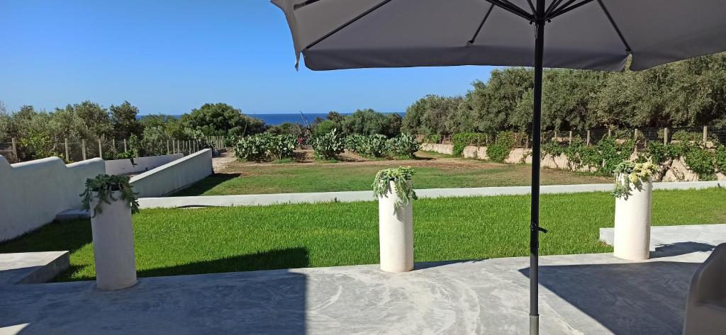 un tavolo con ombrellone e prato di Villa Cad'à a Cava dʼAliga