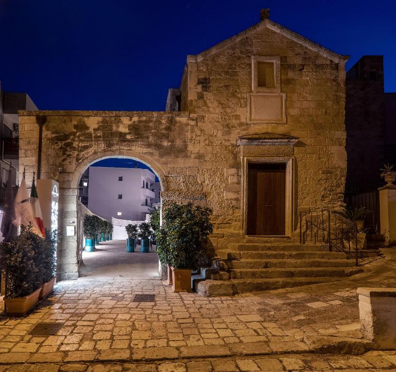un ingresso a un antico edificio in pietra con arco di Dimora San Giuseppe Hotel & SPA a Otranto