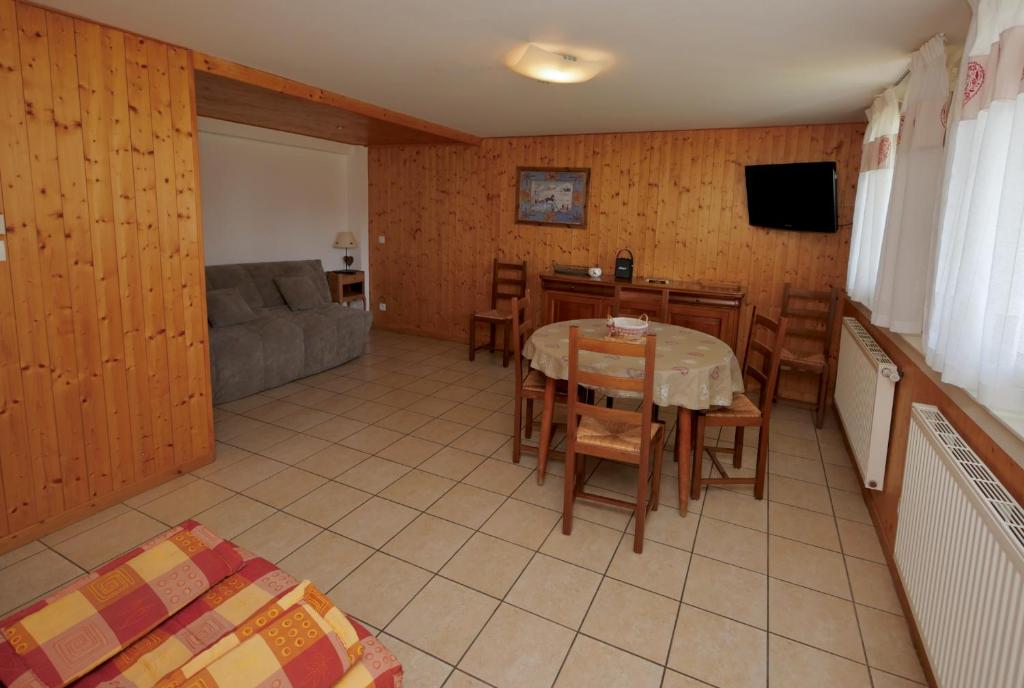 un salon avec une table, des chaises et un canapé dans l'établissement Chalet Crocus Studio, à Huez